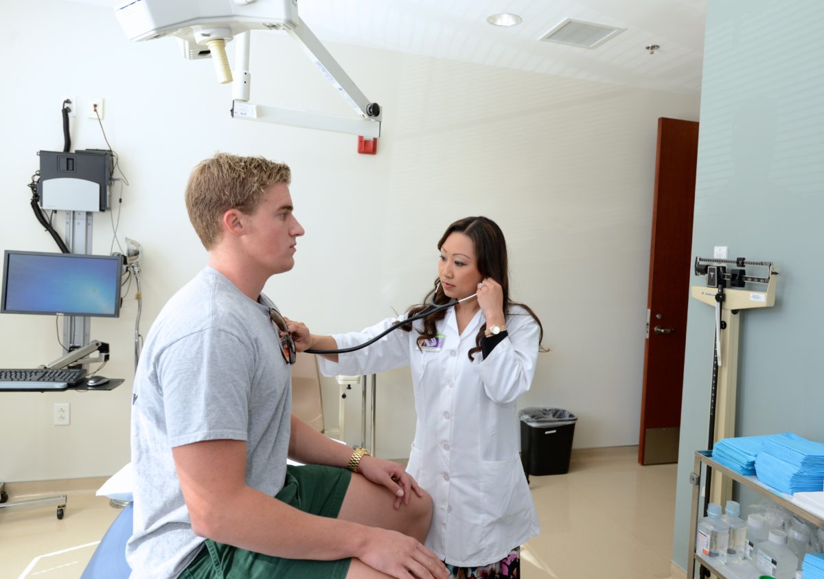 Student at health center being checked by a doctor.