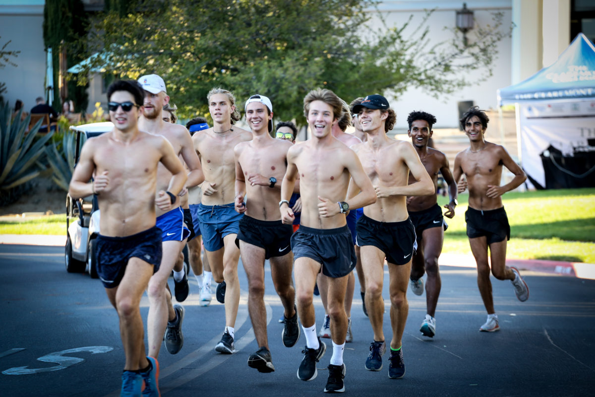 Group of male students running through the street.