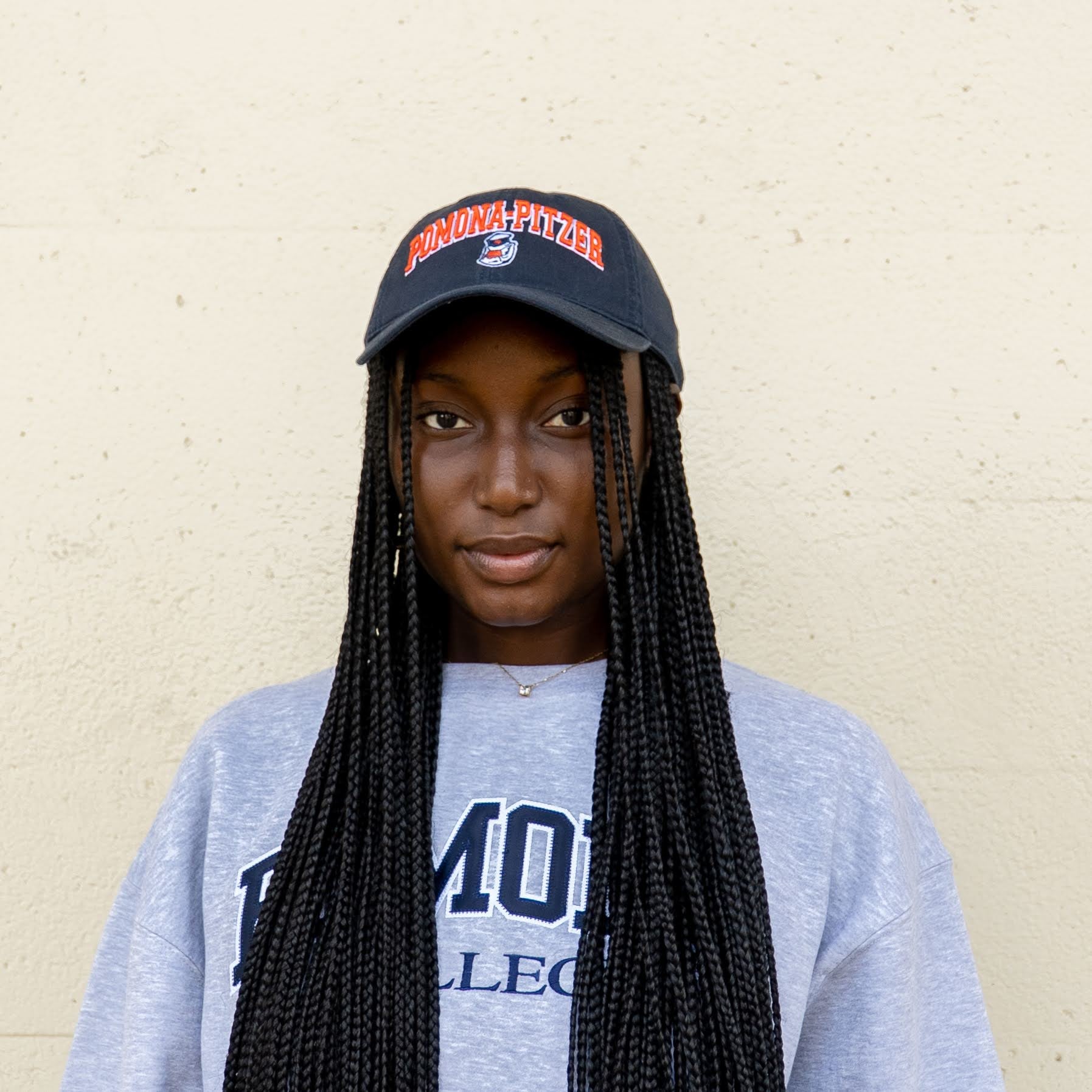 woman wearing pomona-pitzer athletics hat and sweatshirt